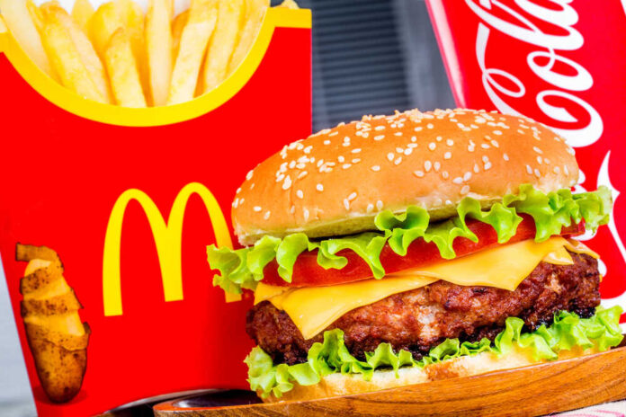 Burger, fries, and cola with red packaging.