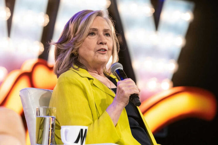 Person in yellow jacket speaks into microphone.