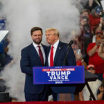 Two men at political rally with Trump Vance 2024.