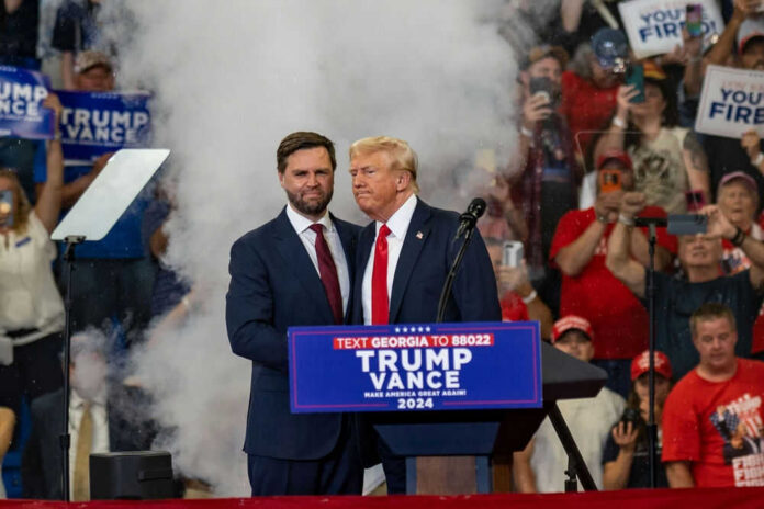 Two men at political rally with Trump Vance 2024.