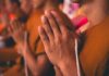 Monks with hands clasped in prayer during a ceremony