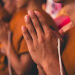 Monks with hands clasped in prayer during a ceremony