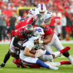 Football players tackling on the field during game