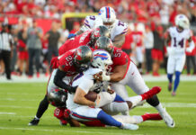 Football players tackling on the field during game