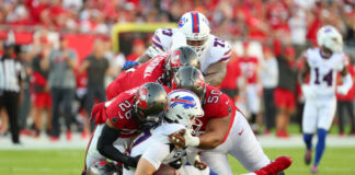 Football players tackling on the field during game