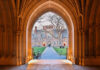 View through an arched doorway leading to a university courtyard