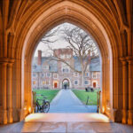 View through an arched doorway leading to a university courtyard