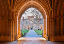 View through an arched doorway leading to a university courtyard
