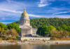 West Virginia State Capitol building with a golden dome surrounded by trees