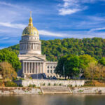 West Virginia State Capitol building with a golden dome surrounded by trees