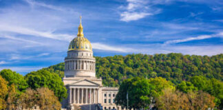 West Virginia State Capitol building with a golden dome surrounded by trees
