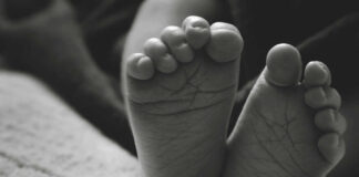 Close-up of a baby's feet resting on a soft surface