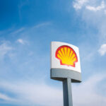 Shell gas station sign against a clear blue sky