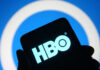 HBO logo displayed on a smartphone against a blue background
