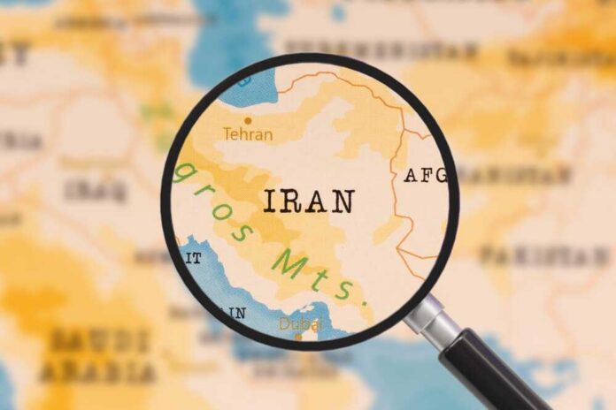 A magnifying glass focusing on the country Iran on a map