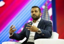 A speaker gesturing while discussing on stage at a conference