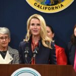 A woman speaking at a press conference with other women in the background