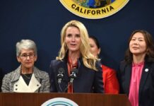A woman speaking at a press conference with other women in the background
