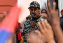 A leader in military attire speaking to a crowd