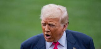 A political figure speaking outdoors with an expressive gesture