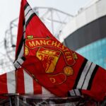 Manchester United flag waving near a stadium