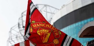 Manchester United flag waving near a stadium