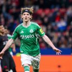 Soccer player in green jersey celebrating a goal