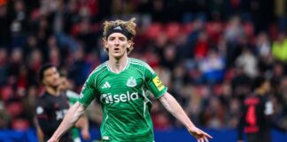 Soccer player in green jersey celebrating a goal