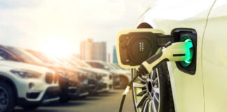 Electric vehicle charging at a station with other cars in the background