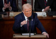 Man in suit speaking at a podium during an event