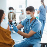Healthcare worker vaccinating woman in clinic setting