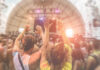 Crowd at a music festival with hands raised in celebration
