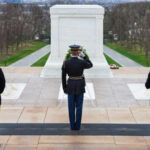 Military personnel saluting at the Tomb of the Unknown Soldier