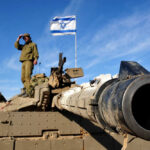 Soldier saluting from atop a tank with an Israeli flag in the background