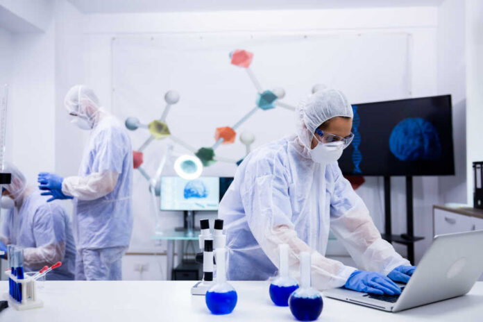 Scientists in a lab conducting research with equipment and a computer