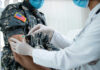 A healthcare professional administering a vaccine to a soldier