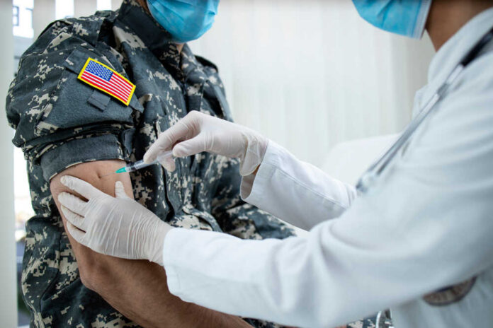 A healthcare professional administering a vaccine to a soldier