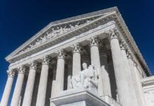 The Supreme Court building featuring columns and a statue of justice