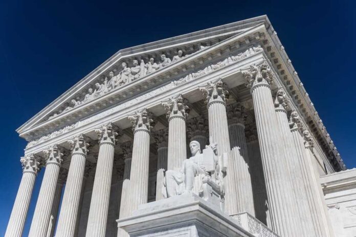 The Supreme Court building featuring columns and a statue of justice