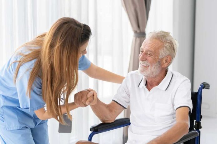 Healthcare worker assisting a smiling elderly man in a wheelchair