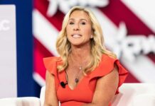 A woman in a red dress speaking at a conference