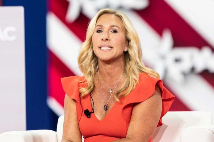 A woman in a red dress speaking at a conference