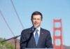 A man speaking at a podium with the Golden Gate Bridge in the background