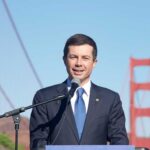 A man speaking at a podium with the Golden Gate Bridge in the background