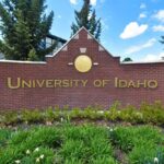 Sign for the University of Idaho displayed on a brick wall