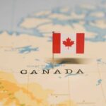 A small Canadian flag pinned on a map indicating Canada
