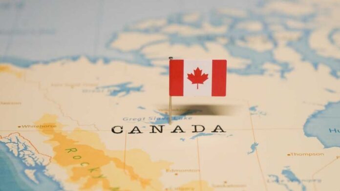 A small Canadian flag pinned on a map indicating Canada