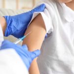 A healthcare professional administering a vaccine to a child's arm