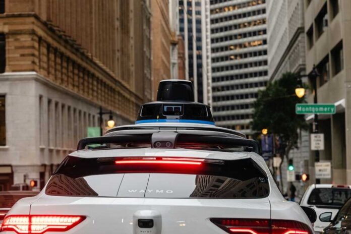 Rear view of a Waymo autonomous vehicle on a city street