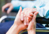 Two hands clasped together, symbolizing care and support